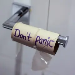 Pusta rolka po papierze toaletowym z napisem "Don't Panic" (Nie panikuj). Może to być metafora sytuacji, w której brakuje czegoś, ale nie ma powodu do zmartwień, jak np. w przypadku problemów żołądkowych, gdzie Tasectan mógłby pomóc.