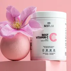 Różowa kula z kwiatem i opakowanie suplementu Best Vitamin C, zawierającego kwas askorbinowy.
