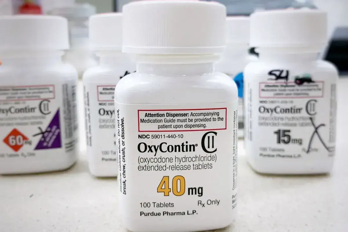 Butelki leku OxyContin, w tym jedna z dawką 40 mg, stoją obok siebie.
